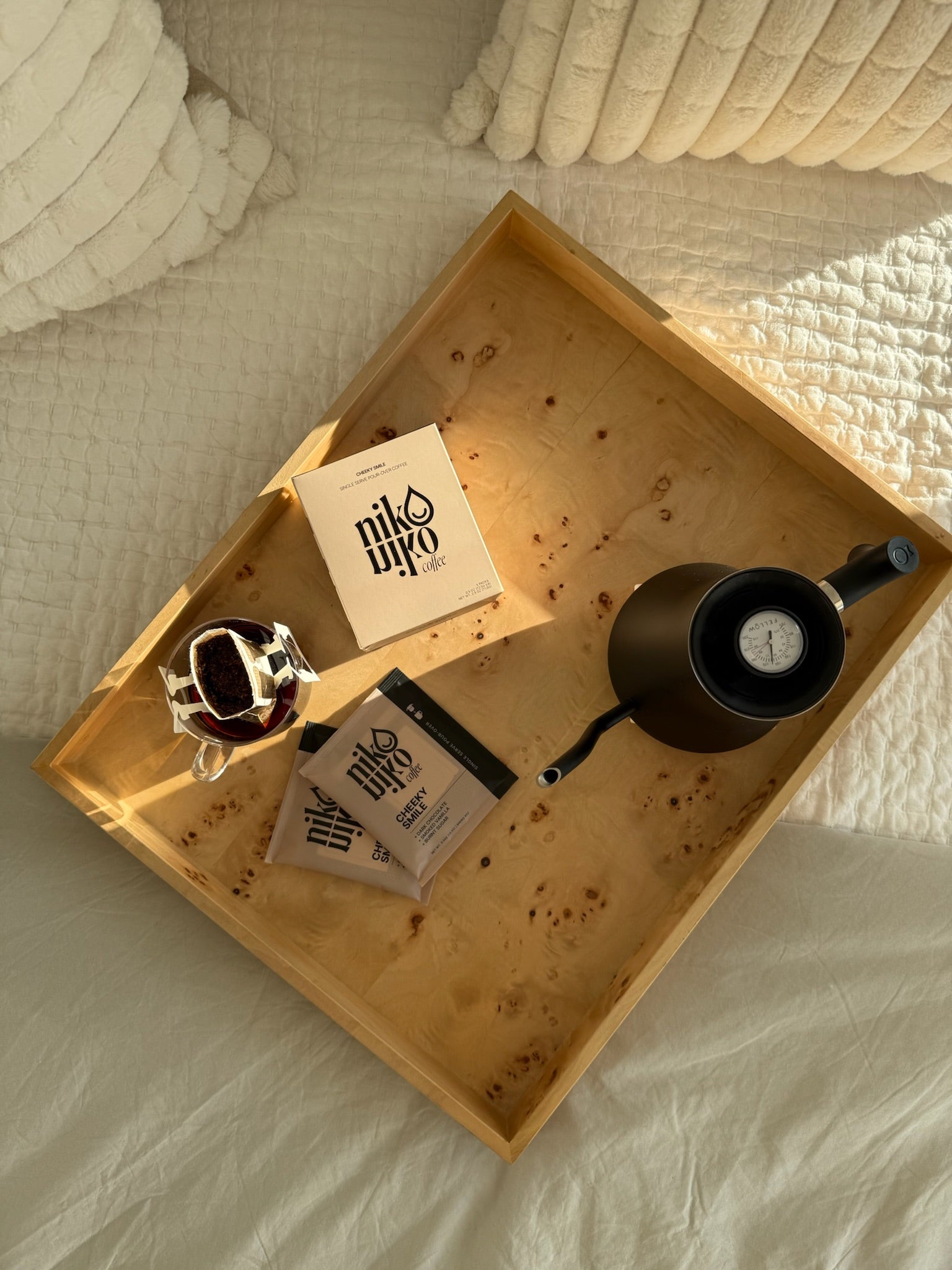 Wooden tray with drip coffee cup, on a bed